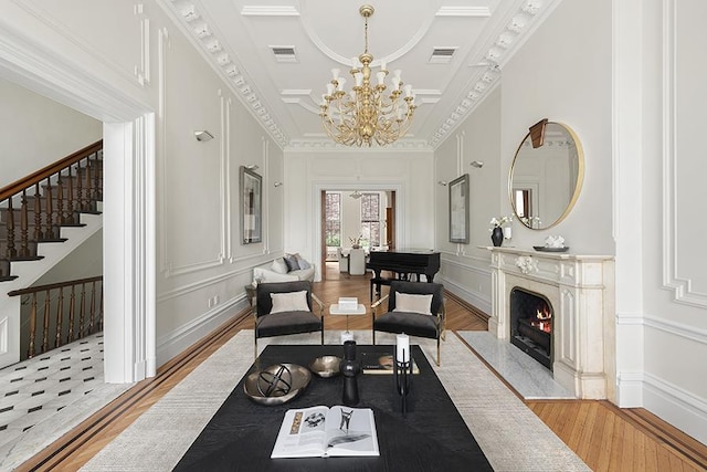 sitting room with visible vents, light wood-style floors, a premium fireplace, and a decorative wall