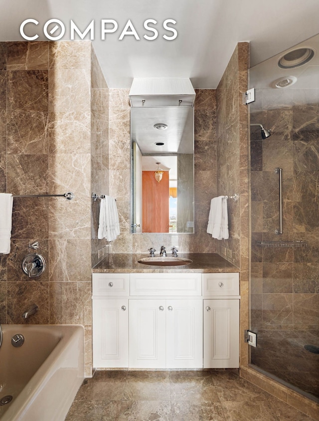 full bathroom with tile walls, vanity, and shower / bathing tub combination