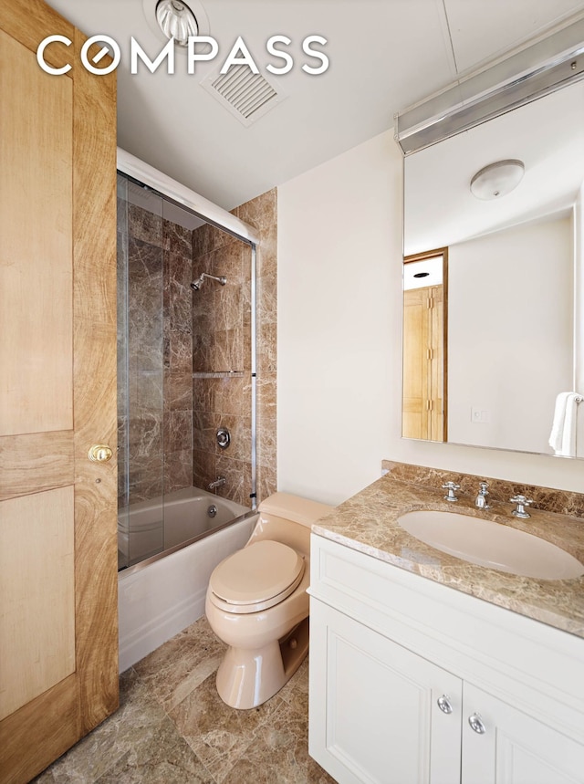 bathroom with combined bath / shower with glass door, visible vents, toilet, and vanity