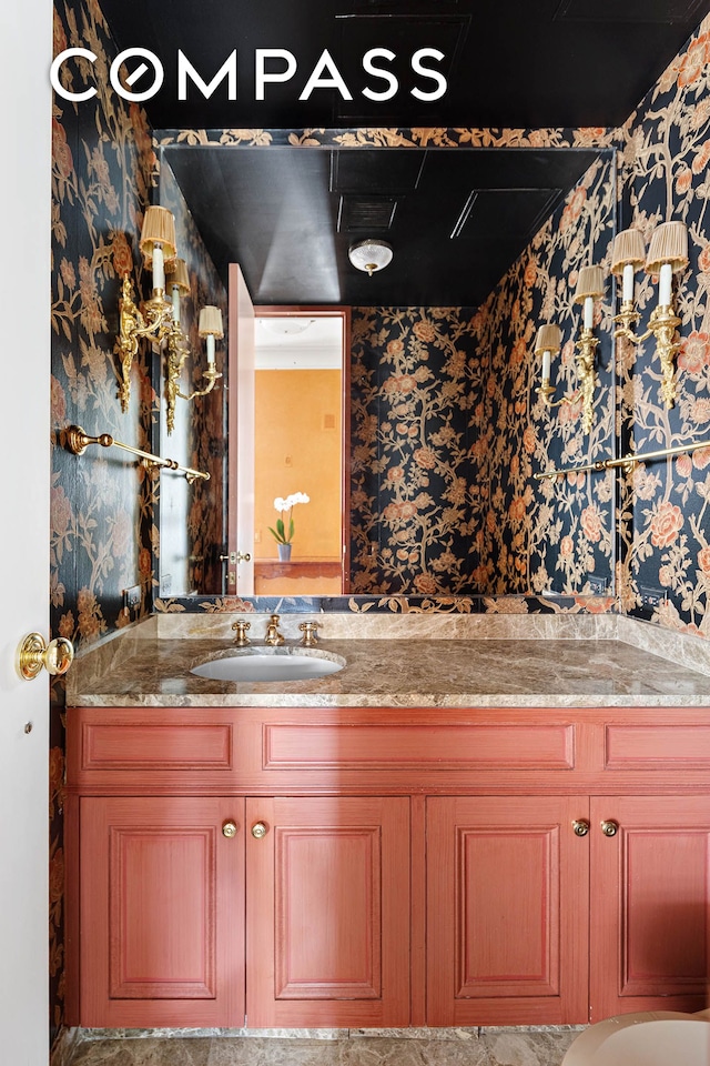 bathroom featuring vanity and wallpapered walls