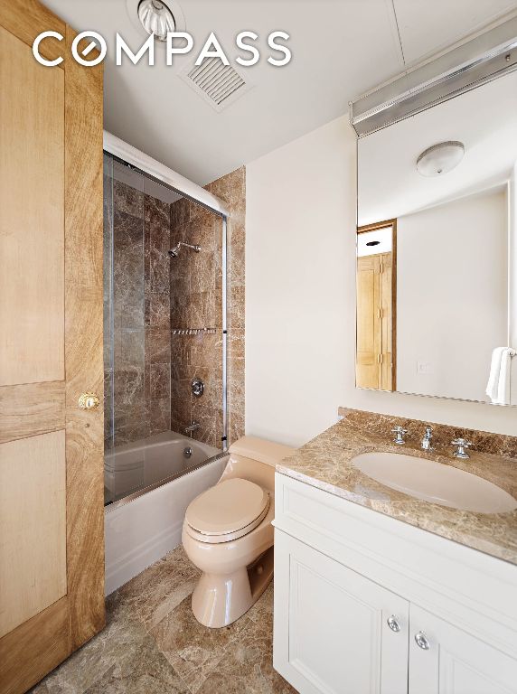 full bathroom featuring vanity, toilet, and combined bath / shower with glass door