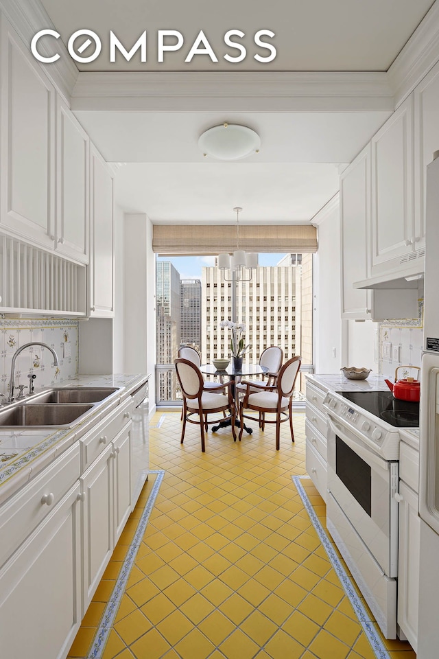 kitchen with tasteful backsplash, light countertops, white cabinets, white appliances, and a sink