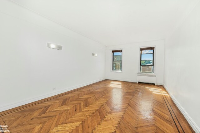 empty room featuring light parquet flooring and radiator