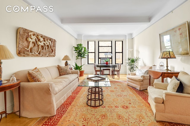 living area featuring beam ceiling, plenty of natural light, and wood finished floors