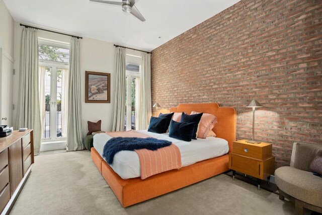 living room with ceiling fan, brick wall, a fireplace, and light hardwood / wood-style flooring