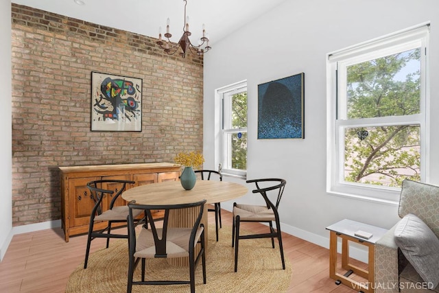 dining space with an inviting chandelier, a wealth of natural light, and light wood-type flooring