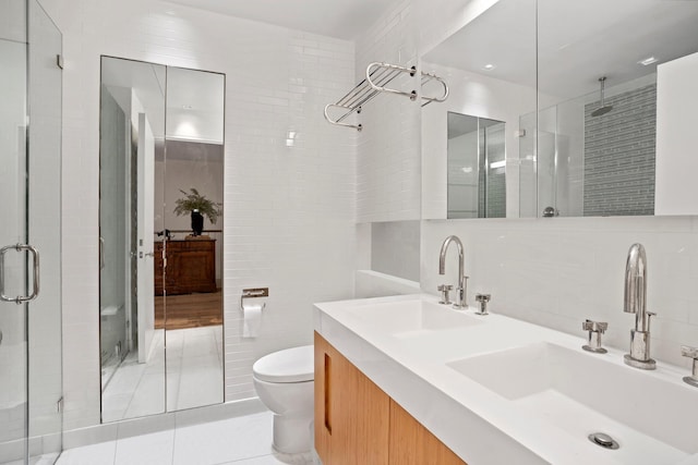 308 E 30th St Unit 1, New York City, NY 10016 - full bathroom featuring tile walls, a stall shower, double vanity, and tile patterned flooring