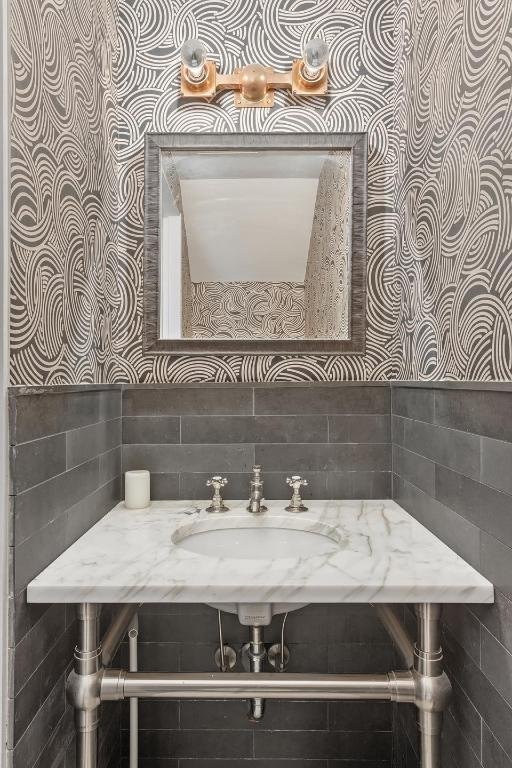 bathroom with sink and tile walls