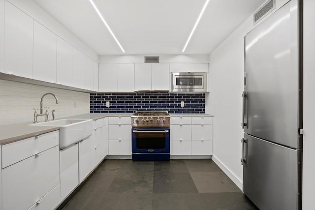 kitchen with white cabinetry, sink, backsplash, and appliances with stainless steel finishes