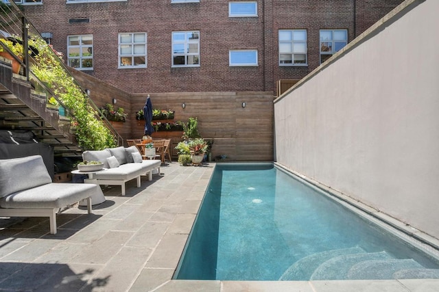 view of pool with an outdoor living space and a patio area