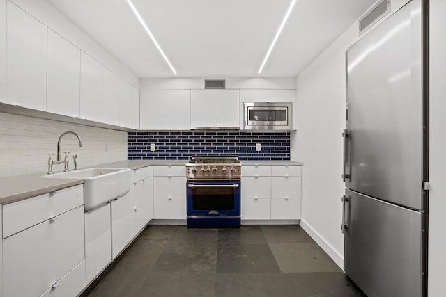 308 E 30th St Unit 1, New York City, NY 10016 - kitchen featuring stainless steel appliances, decorative backsplash, and white cabinets