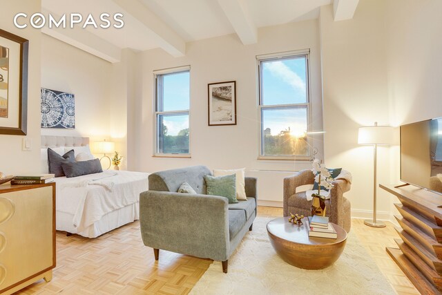 sitting room with baseboards and beam ceiling