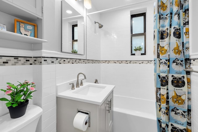 bathroom featuring toilet, shower / tub combo, tile walls, and vanity