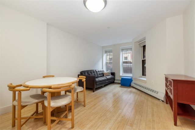 dining room featuring baseboard heating and light wood-type flooring