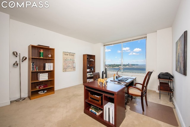 home office featuring light colored carpet and a water view