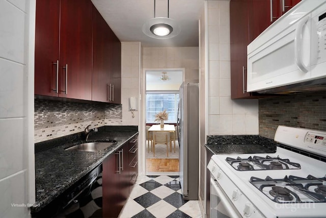 kitchen featuring sink, dark stone countertops, backsplash, and white appliances