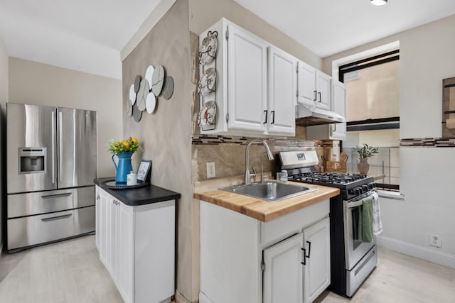 kitchen with sink, light hardwood / wood-style flooring, white cabinetry, backsplash, and stainless steel appliances