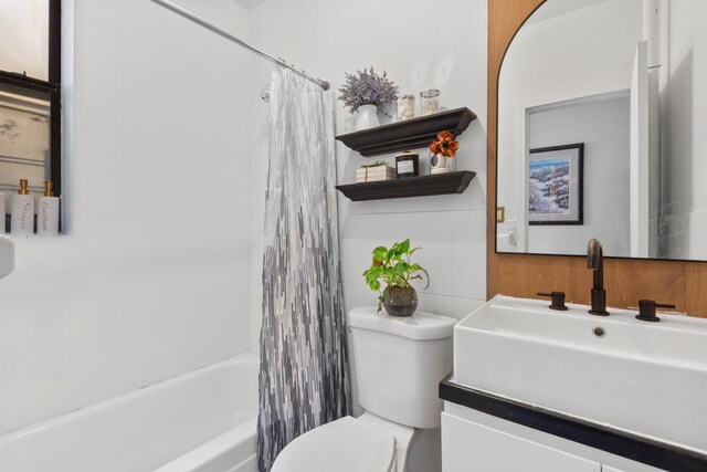 full bathroom featuring vanity, shower / bath combo with shower curtain, and toilet