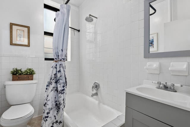 full bathroom with vanity, toilet, tile walls, and shower / bath combo