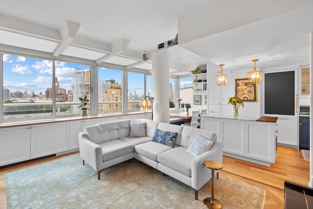2373 Broadway Unit 1903, New York City, NY 10024 - living room featuring a view of skyline, light wood finished floors, coffered ceiling, and a chandelier