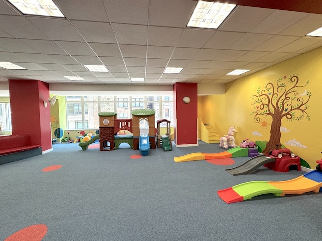 playroom featuring carpet flooring and a drop ceiling