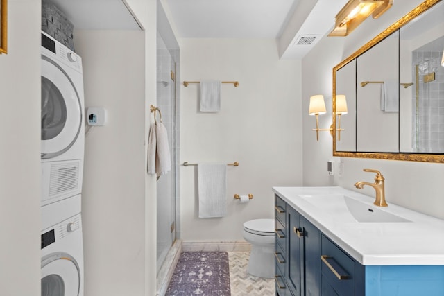 2373 Broadway Unit 1903, New York City, NY 10024 - full bathroom with stacked washing machine and dryer, toilet, a shower stall, vanity, and baseboards