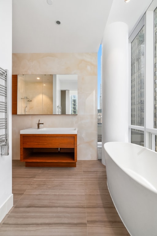 bathroom with vanity and a bath