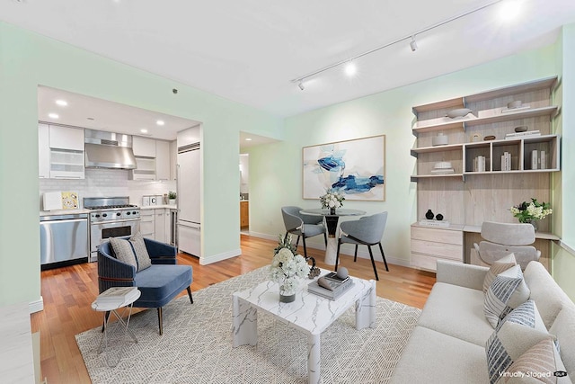 living room with light wood-style floors, baseboards, and recessed lighting