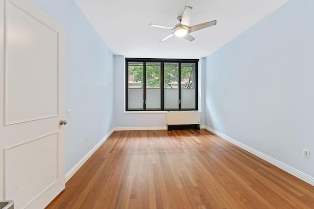 empty room with ceiling fan and light hardwood / wood-style flooring