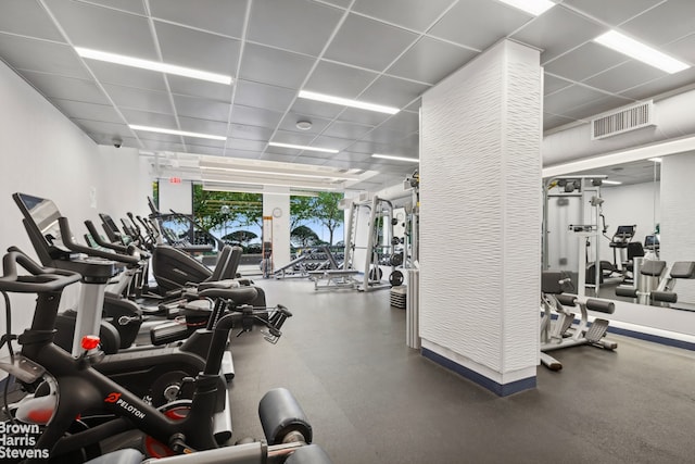 exercise room with a drop ceiling and floor to ceiling windows