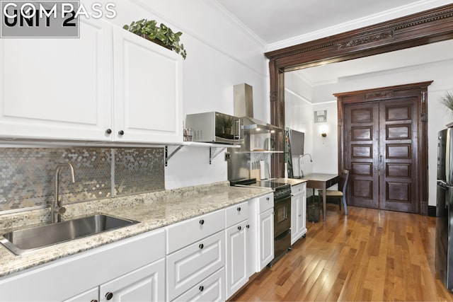 kitchen with white cabinetry, wall chimney exhaust hood, dark hardwood / wood-style floors, crown molding, and black range with electric stovetop