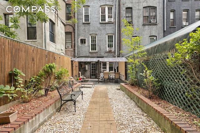 rear view of house with a patio, brick siding, and a fenced backyard