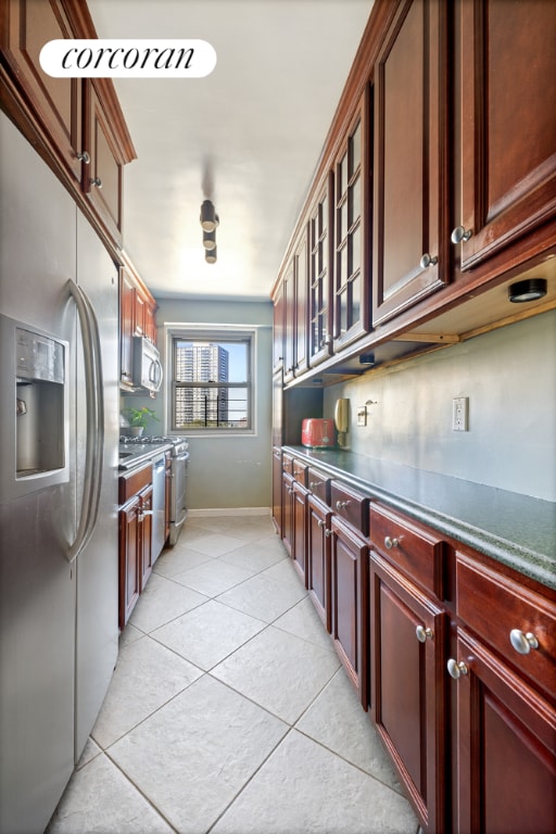 kitchen featuring light tile patterned floors, backsplash, and stainless steel appliances