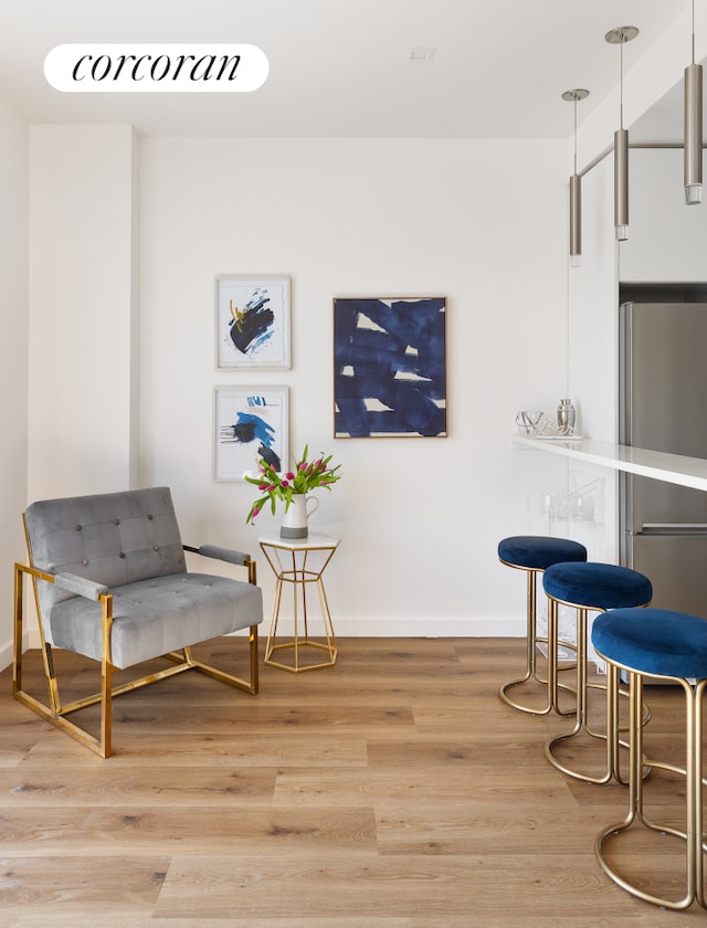 sitting room with light wood-type flooring and baseboards