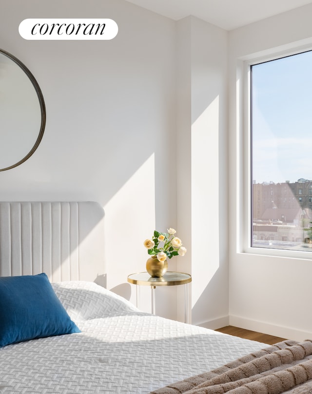 bedroom with baseboards and wood finished floors