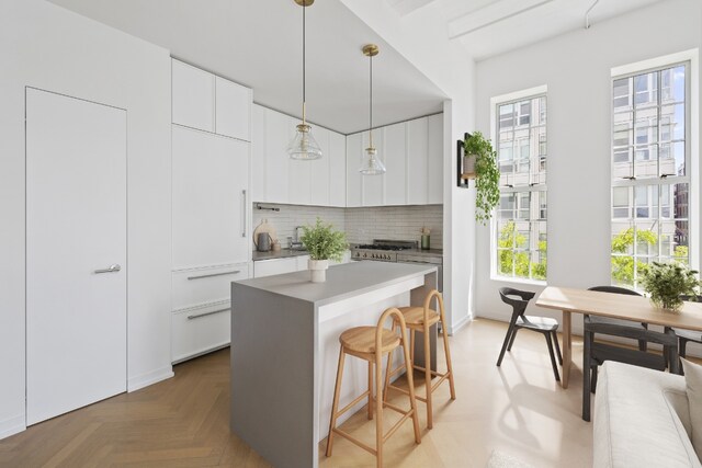 kitchen with light parquet floors, white cabinetry, and a center island