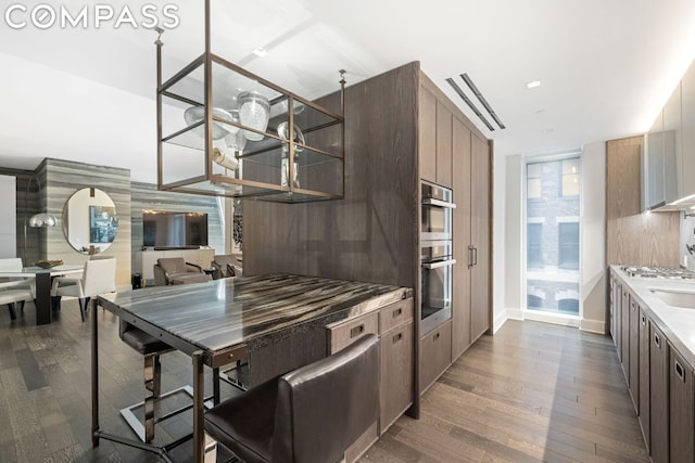 kitchen with dark wood-type flooring and stainless steel double oven