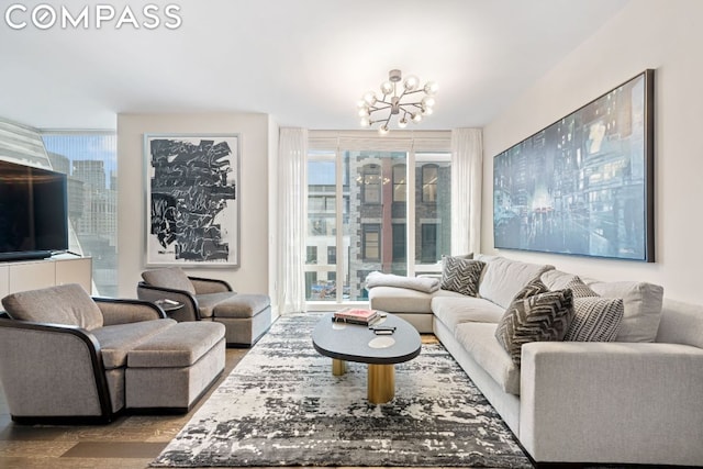 living room featuring an inviting chandelier, plenty of natural light, and hardwood / wood-style floors