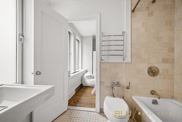 full bathroom featuring toilet, bathtub / shower combination, a sink, and tile walls