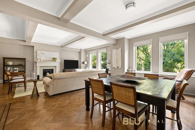 dining area with baseboards, a fireplace, and beamed ceiling