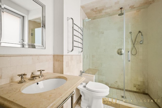 full bath with vanity, wainscoting, a shower stall, and toilet