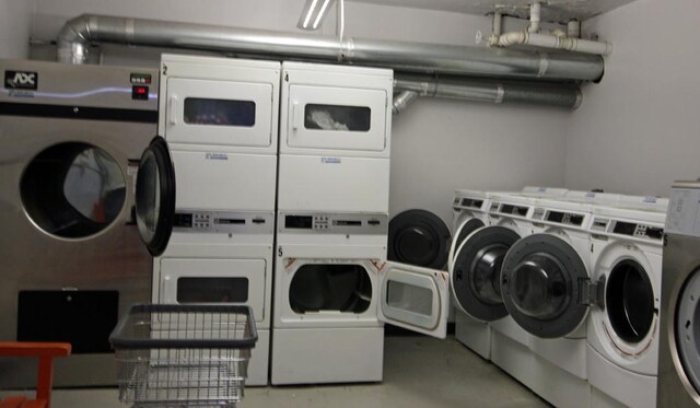community laundry room featuring stacked washer / drying machine and washer and clothes dryer