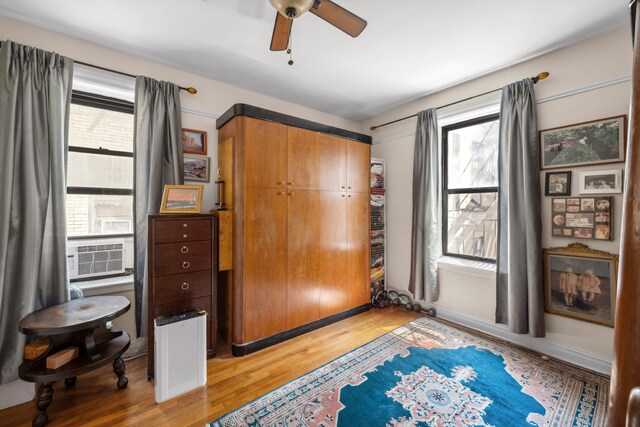 bedroom featuring light wood-style floors, a closet, ceiling fan, and cooling unit