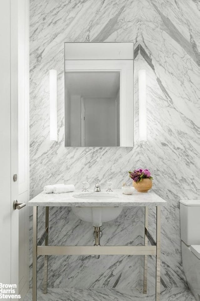 bathroom featuring toilet, tasteful backsplash, and a sink