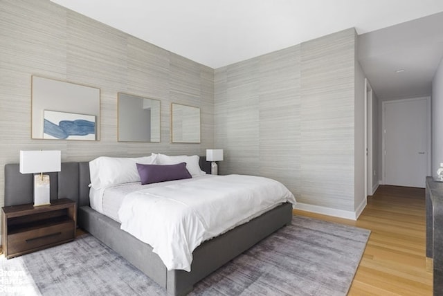 bedroom with baseboards and wood finished floors