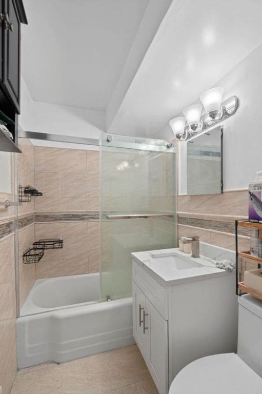 full bathroom featuring toilet, tiled shower / bath combo, tile patterned floors, and vanity