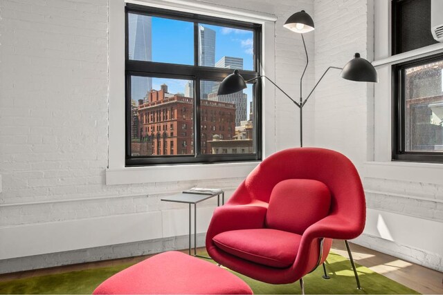 living area featuring brick wall