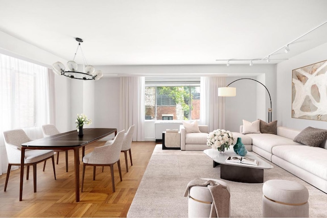 living room with parquet floors and a notable chandelier