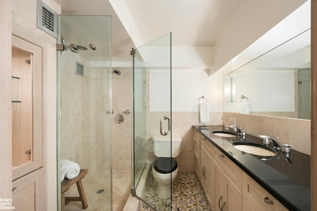 253 W 73rd St Unit 2G, New York City, NY 10023 - bathroom featuring a shower stall, double vanity, and tile walls
