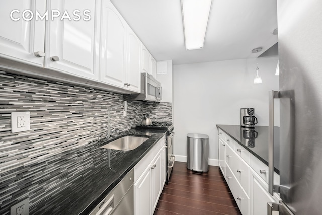 350 E 62nd St Unit 4L, New York City, NY 10065 - kitchen with appliances with stainless steel finishes, a sink, decorative backsplash, dark wood finished floors, and dark stone countertops